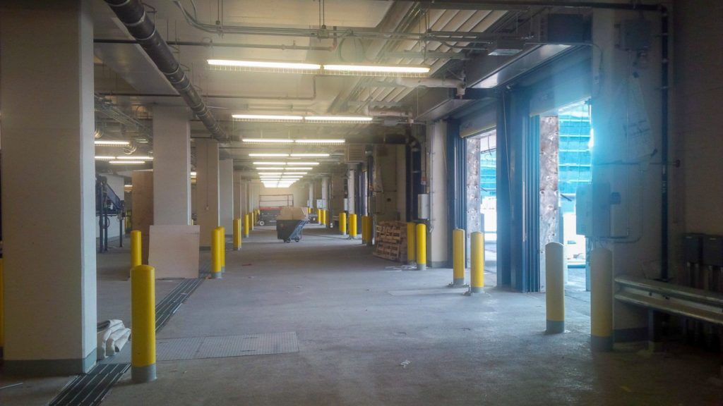 Berner Industrial Direct Drive 12-14 air curtain over dock door in baggage cart loading dock.