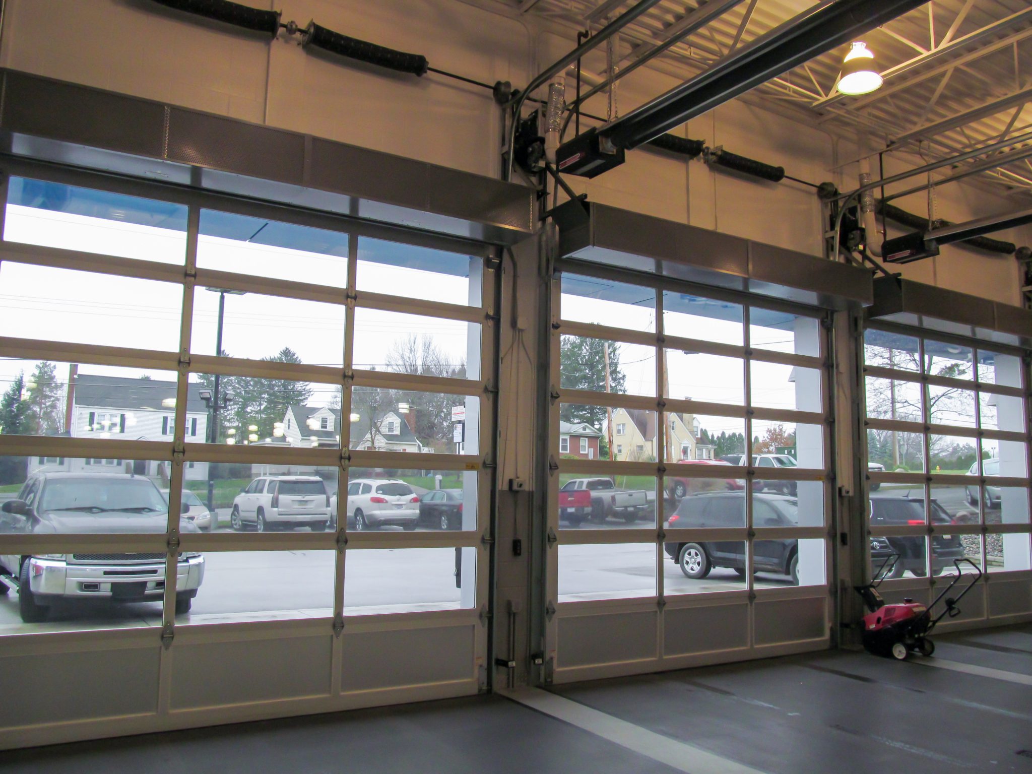 Berner's Industrial Direct Drive 12 and 14 Air Curtains over car dealership garage doors