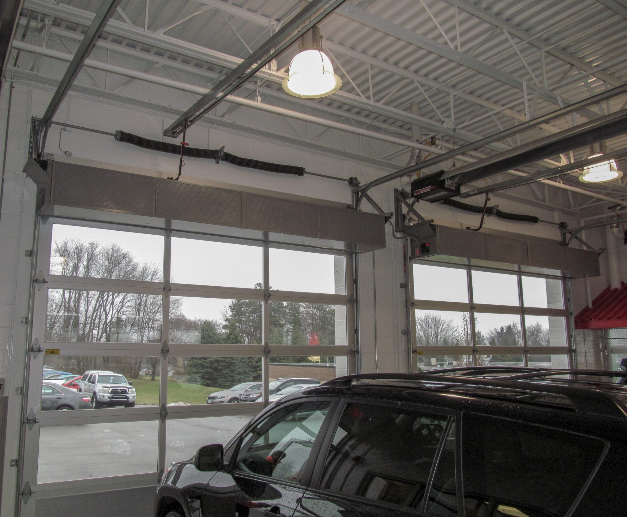 Berner's Industrial Direct Drive 12 Air Curtains over Mel Grata car dealership's service garage doors.