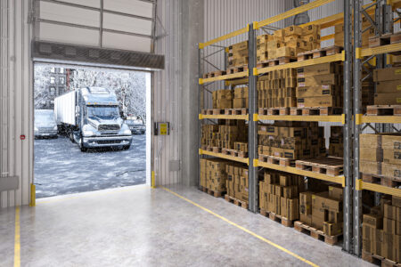 Industrial air curtain protecting a high-traffic shipping and receiving opening